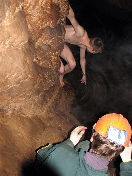 Максим производит замер температуры воды в пещерном озере.